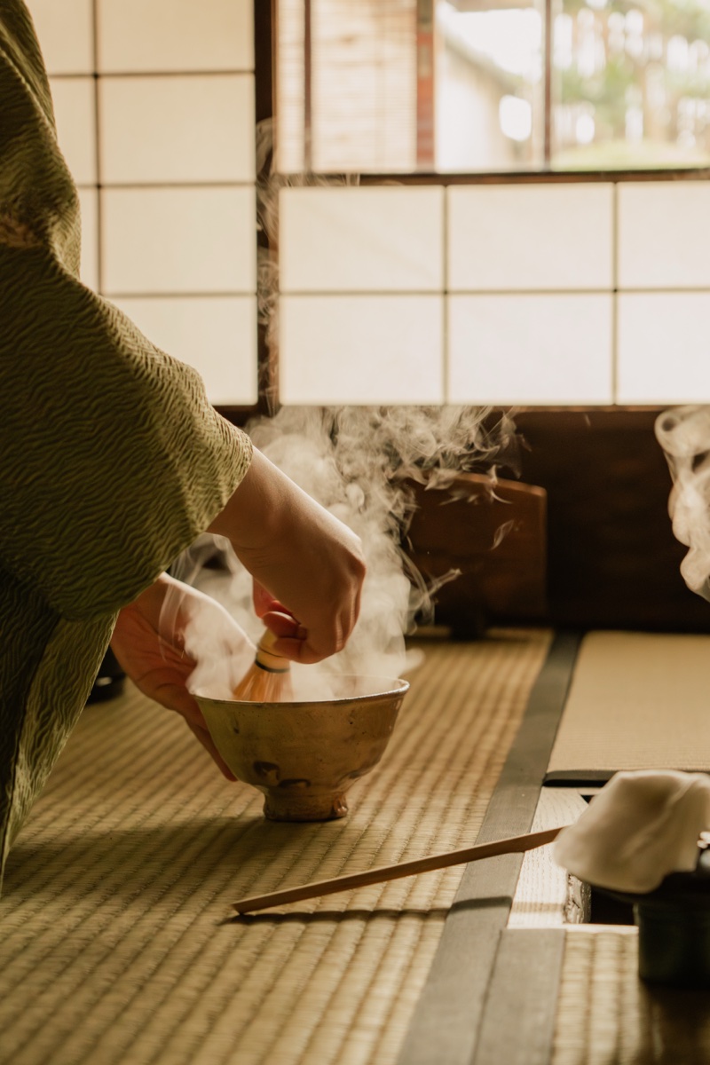 Matcha being whisked in a steaming tea bowl in the morning light