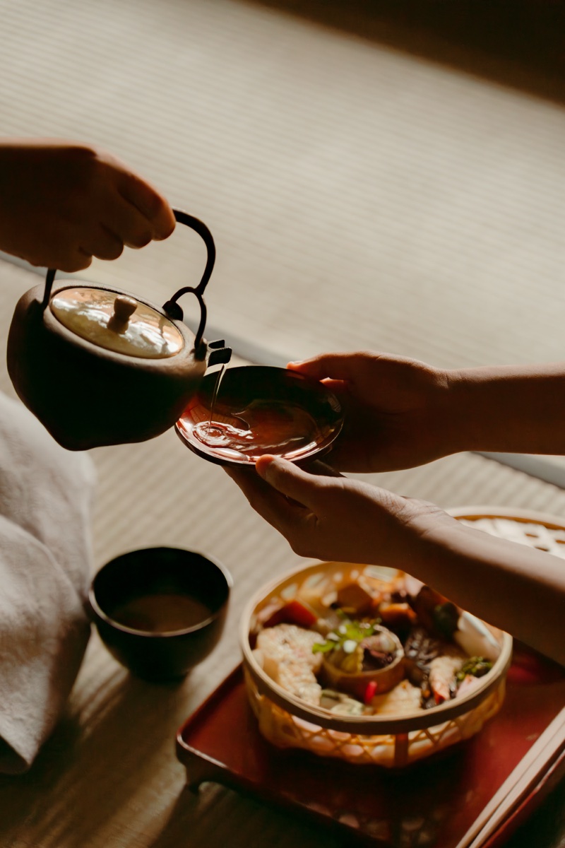 Tea being poured beside a seasonal meal at a tea ceremony