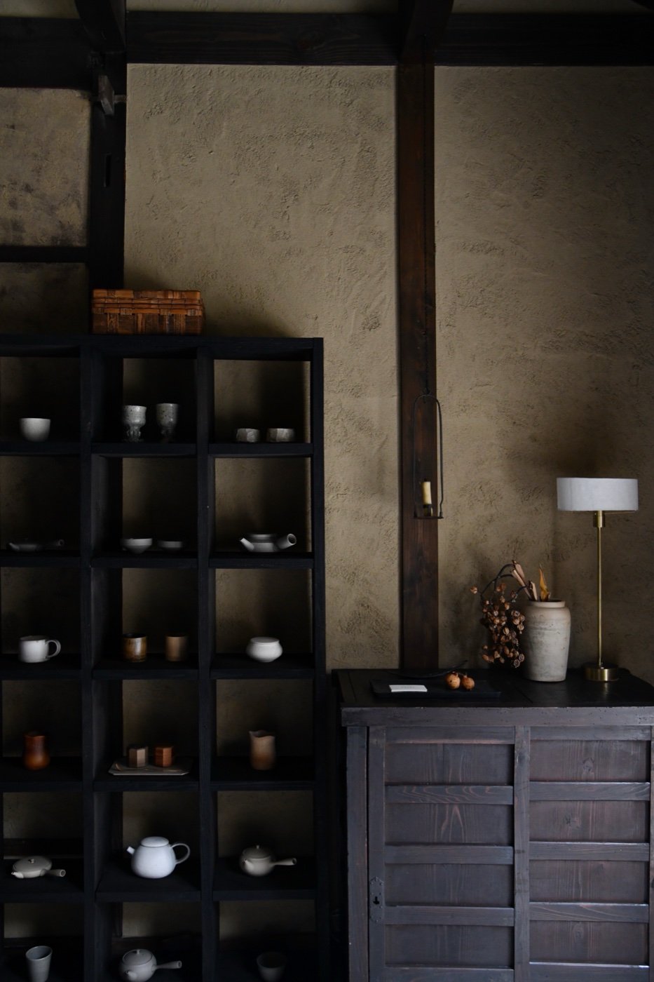 Ceramics and homeware displayed on dark wooden shelves at Maana Living